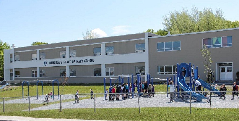 Children playing on playground equipment outside school